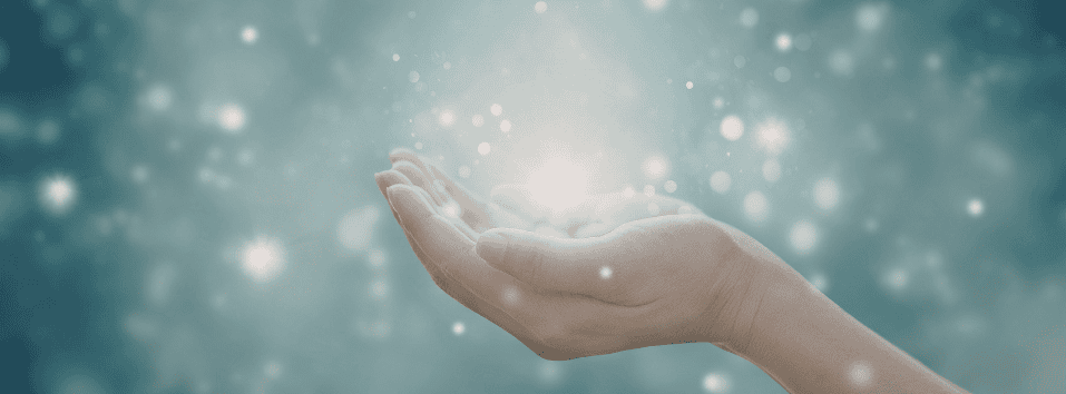 Hoitava käsi ja valoefektiä, symboloi energiaa ja paranemista DG Healing -palveluissa.