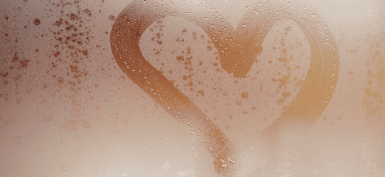 Rakkauden sydän piirtyy saunan ikkunaan höyryssä ja vesipisaroissa.