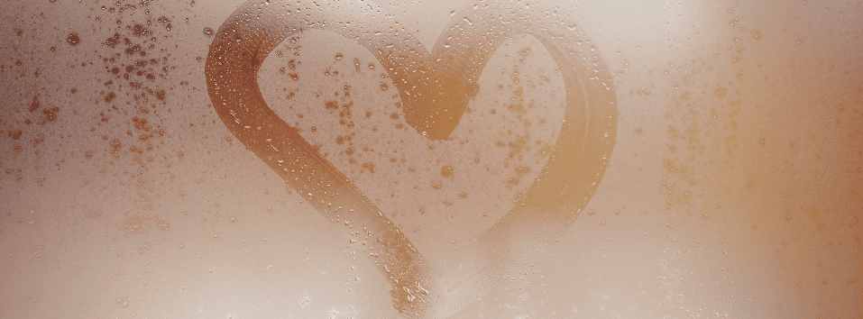 Rakkauden sydän piirtyy saunan ikkunaan höyryssä ja vesipisaroissa.