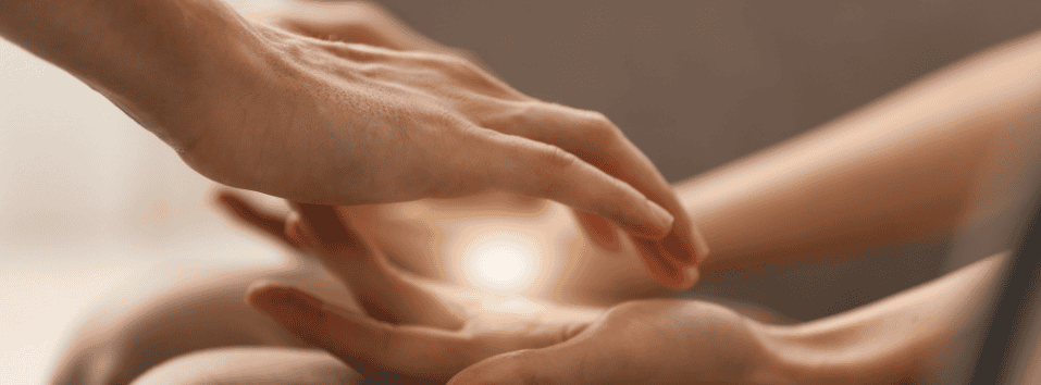 Energiahoitaja suorittaa kädenhoitoa ja energian tasapainotusta.