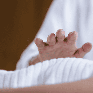 Hoitaja suorittaa energianhoitoa asiakkaalle makuulla.